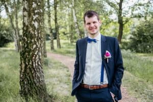 Hochzeitsfotograf Münster - Bräutigam steht im Grünen