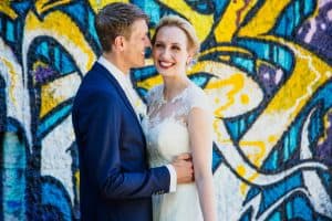 Hochzeit von Tine und Basti in Münster: Brautpaar vor einer bemalten Wand