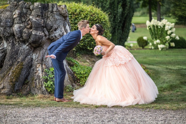 Hochzeit von Tine und Phillip in Münster: Brautpaar küsst sich vor einem Baumstamm