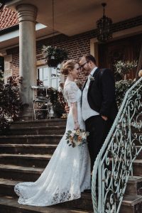 Hochzeit von Jennifer und Stefan in Münster: Brautpaar haben sich im Arm und lächeln sich an