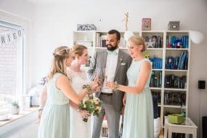 Hochzeit von Jennifer und Stefan in Münster: Braut mit ihren Freunden beim Anstoßen des Sektes